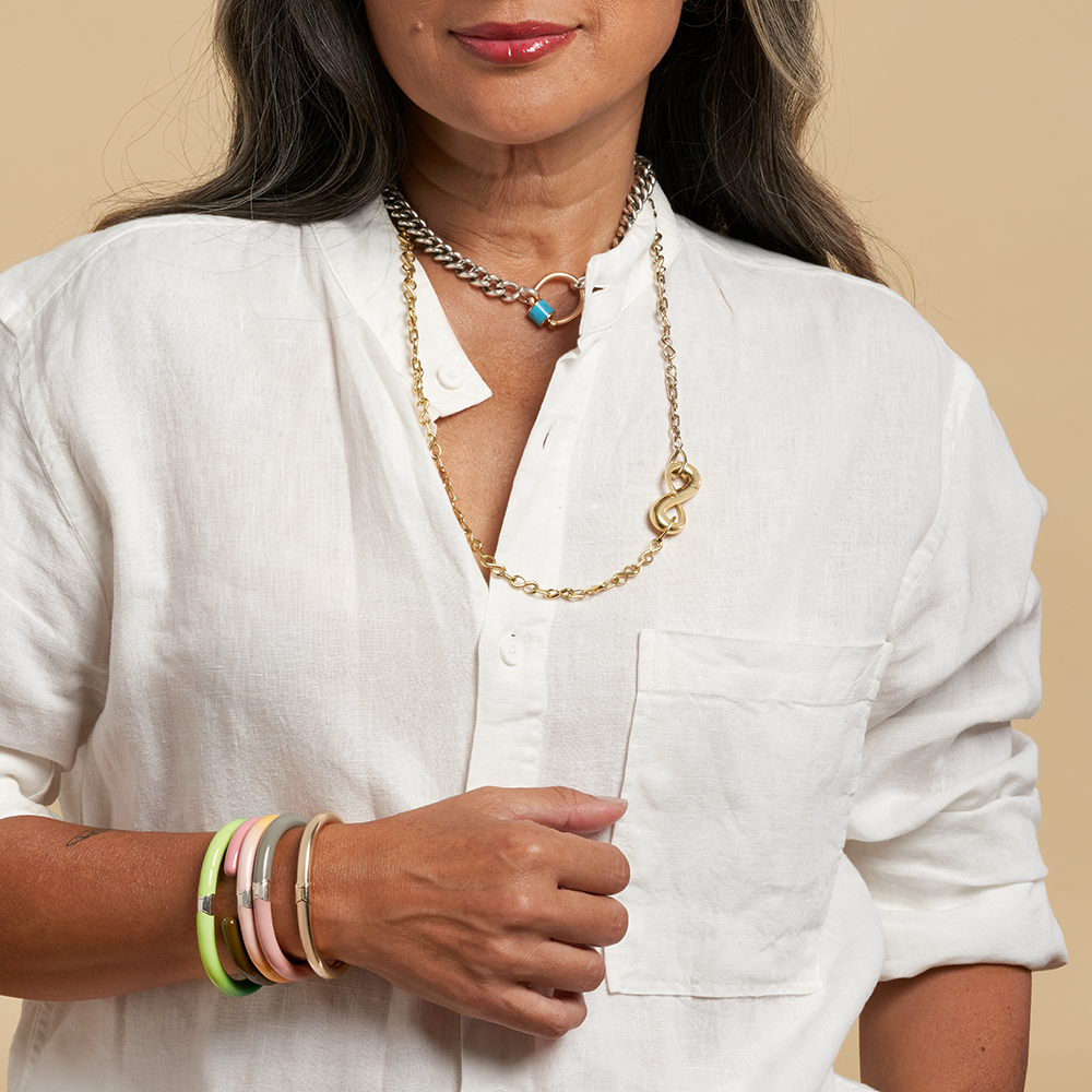 Close up of woman's decolletage wearing gold infinity chain necklace