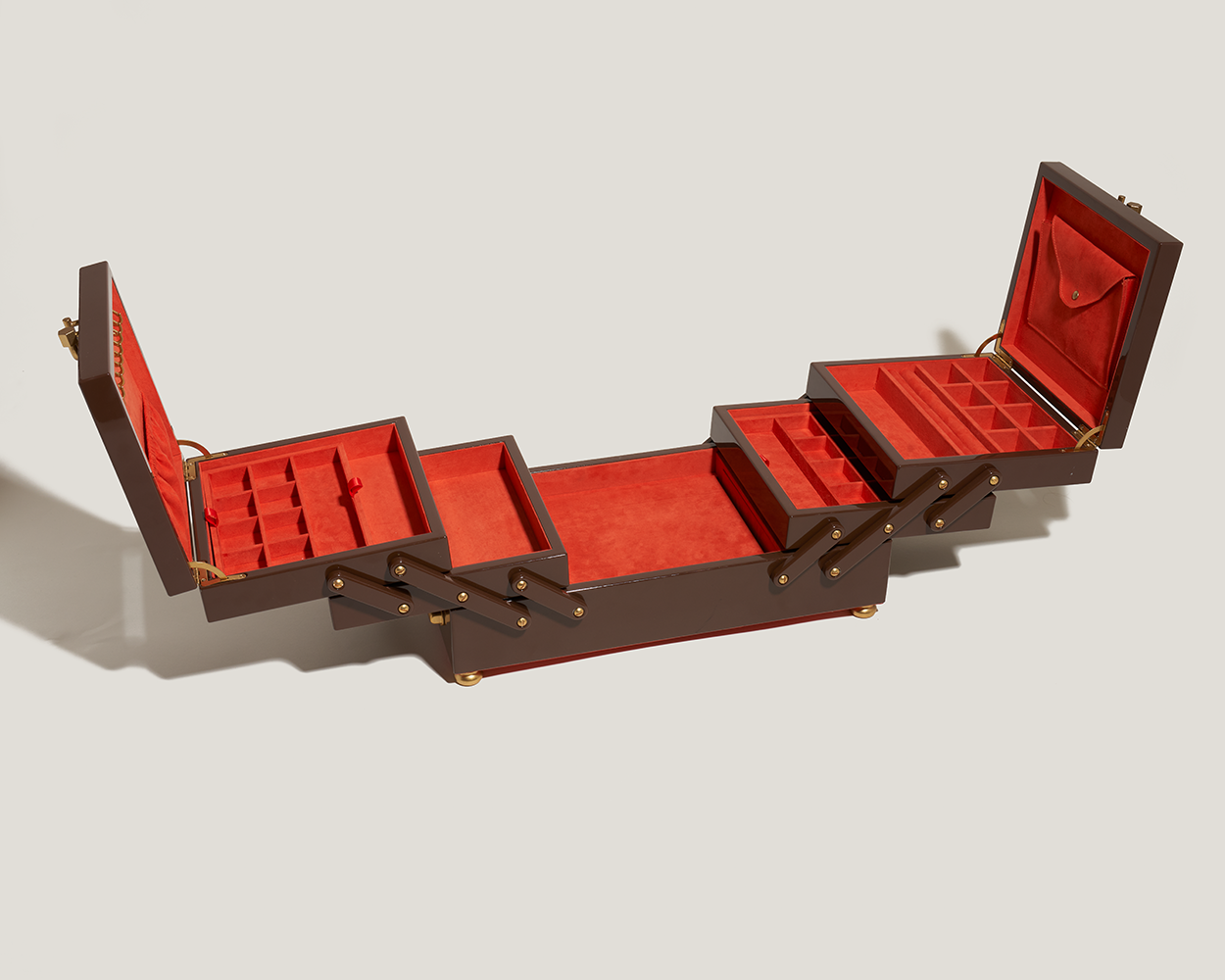 Open jewelry organizer box with wooden exterior and red interior