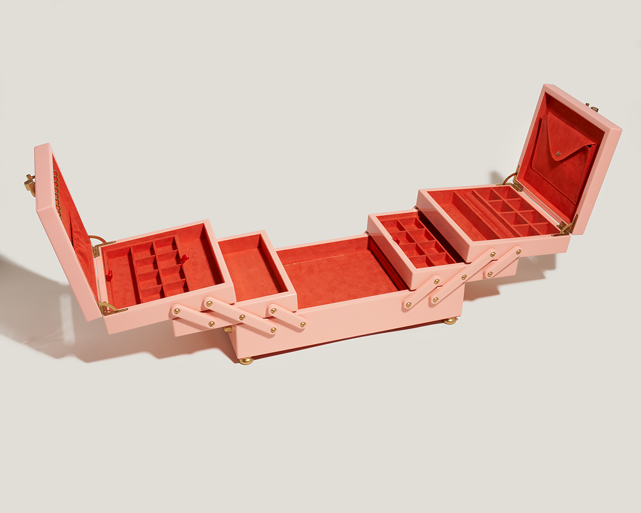 Open pink jewelry organizer box with wooden exterior and red interior