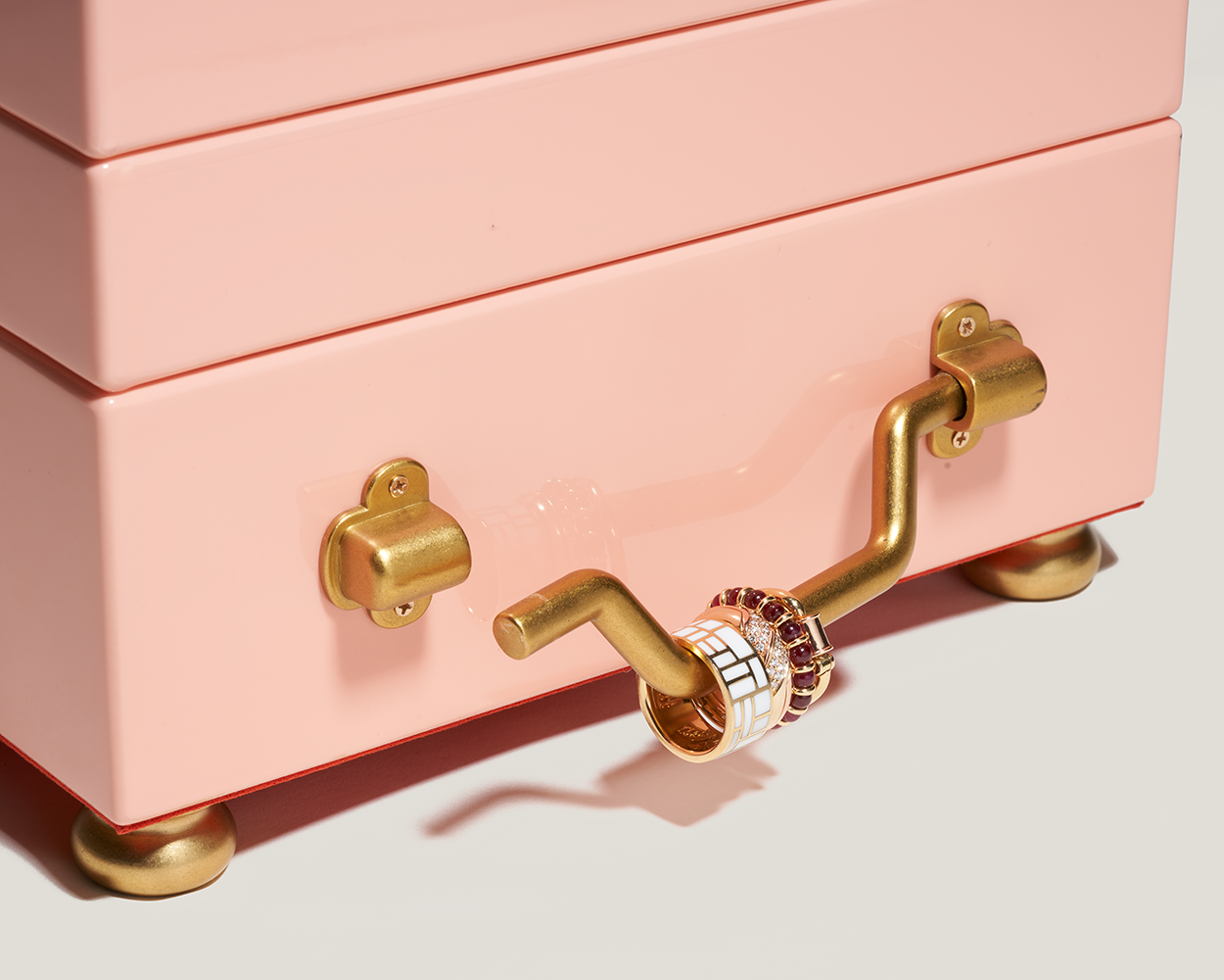 Close up of detached side handle on pink jewelry box with multiple rings attached