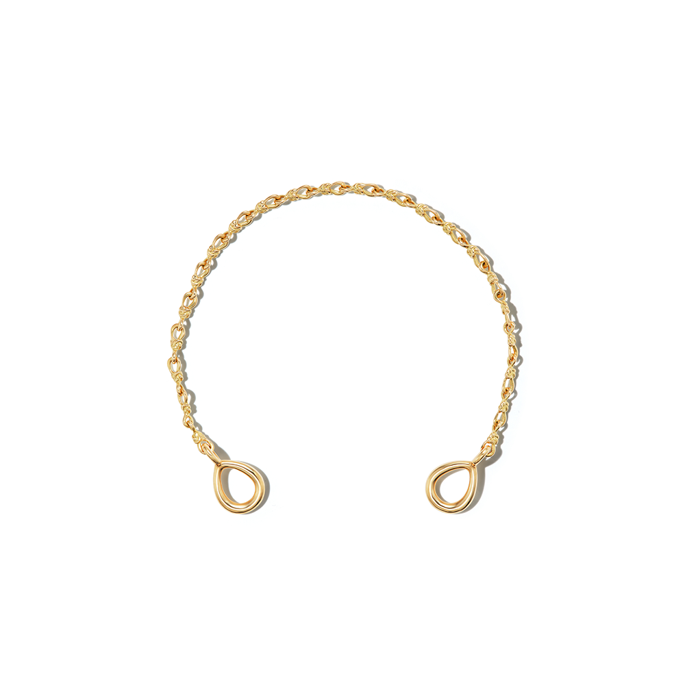 Gold love knot bracelet chain against white backdrop