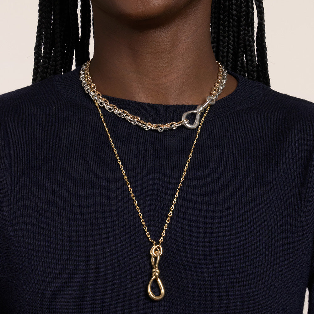 Close up of woman's decolletage wearing silver love chain necklace