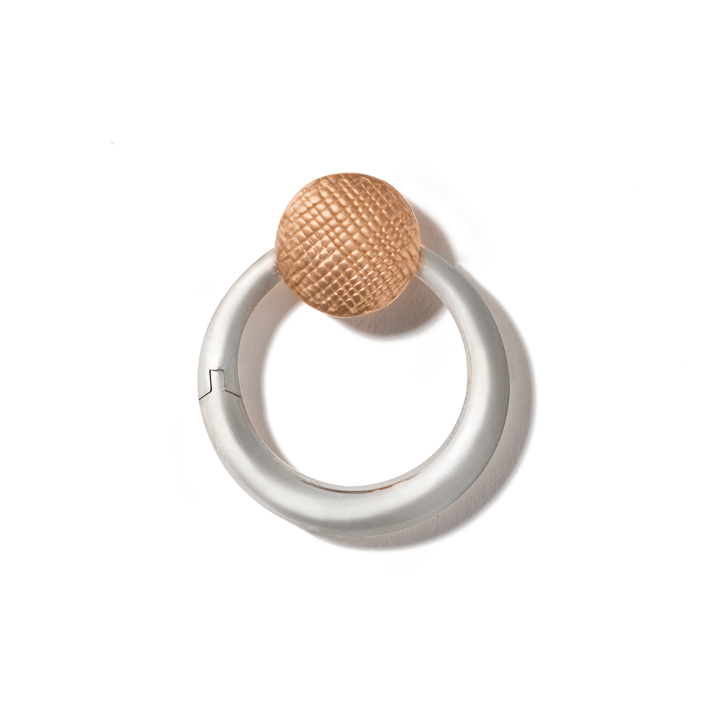Silver circle charm with rose gold clasp against white backdrop