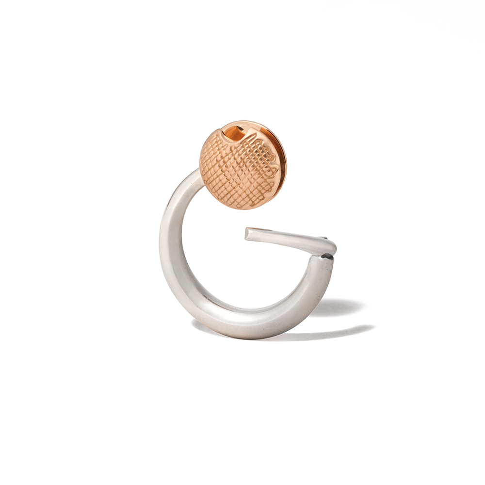 Angled front shot of silver disc charm with rose gold clasp against white backdrop