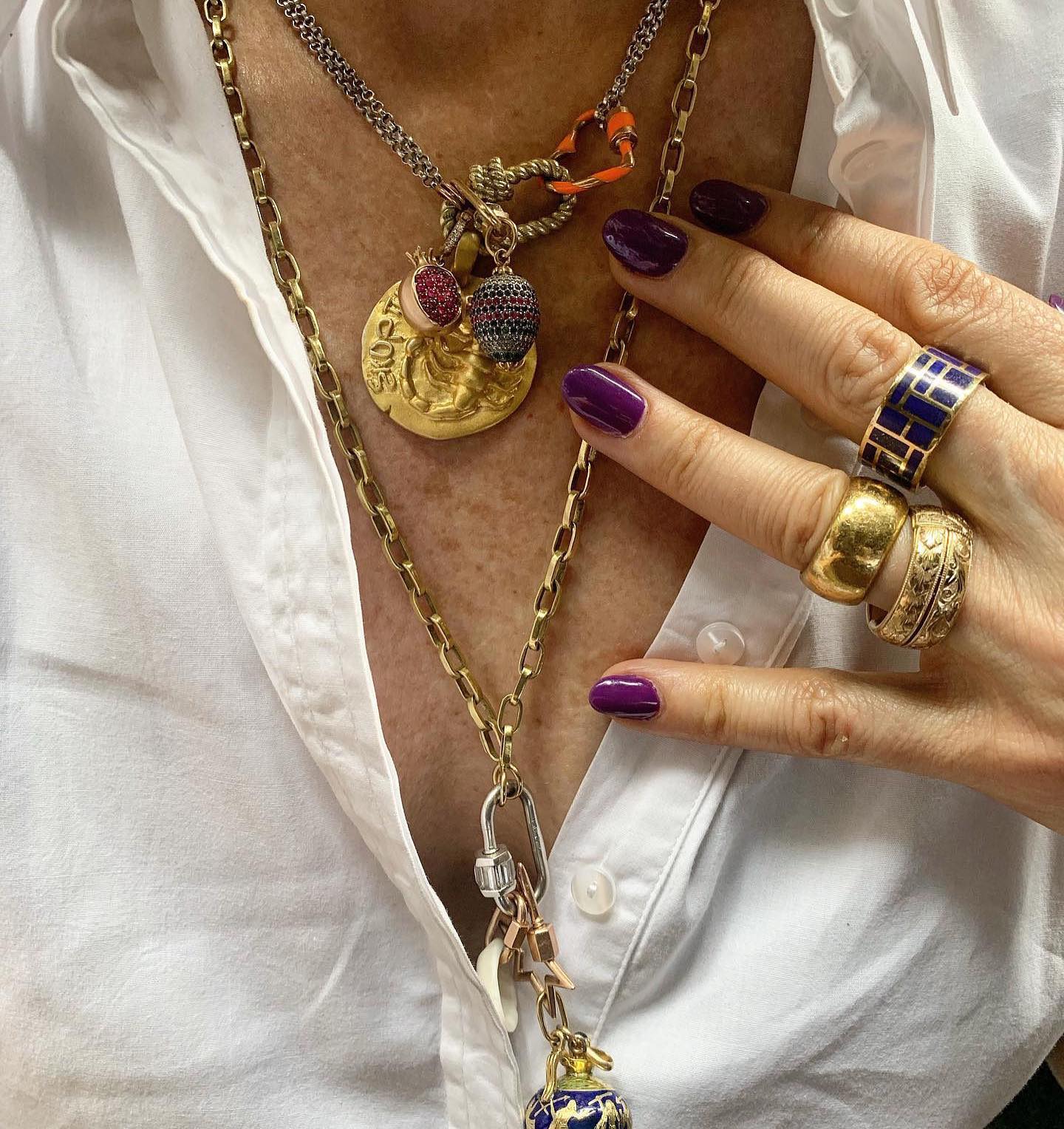 Close up of woman's decolletage wearing necklace with heart orange charm