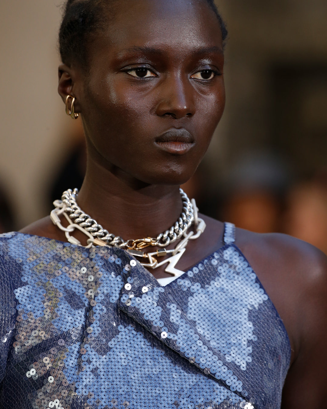 Portrait shot of woman in sparkly dress wearing pierceless earrings