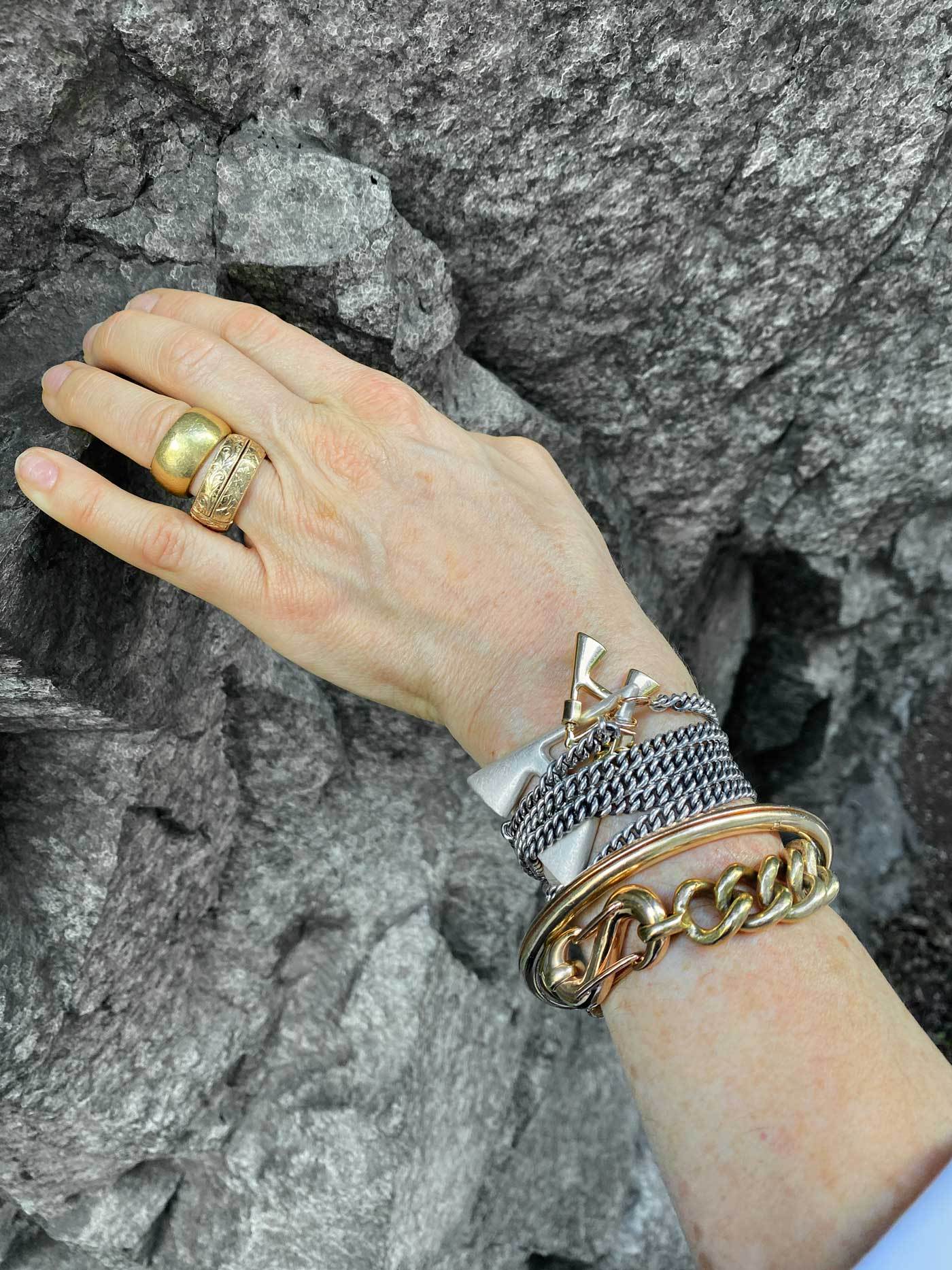 Wrist wearing multiple bracelets including bracelet with A lock