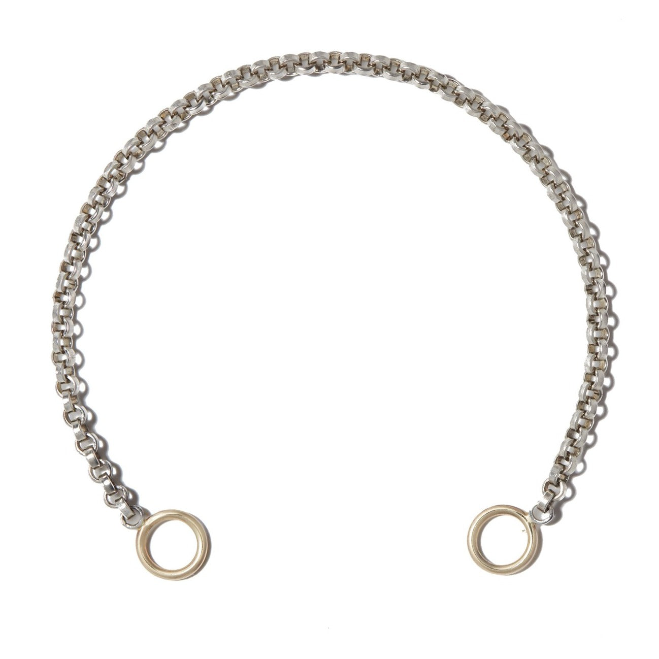Close up shot of silver rolo chain with gold loops against white backdrop