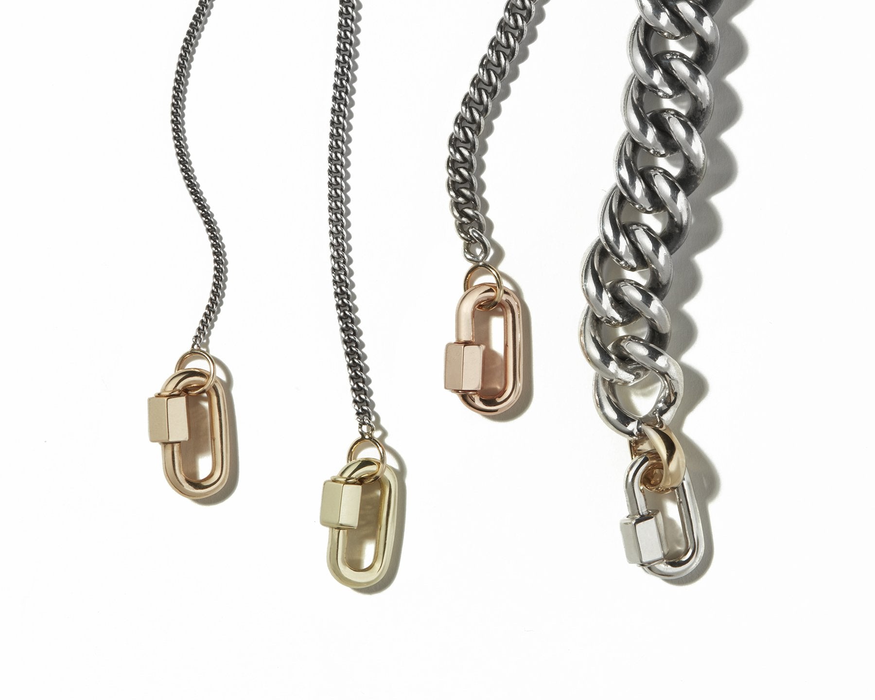 Four curb chains of different thicknesses with lock charms lined up next to each other