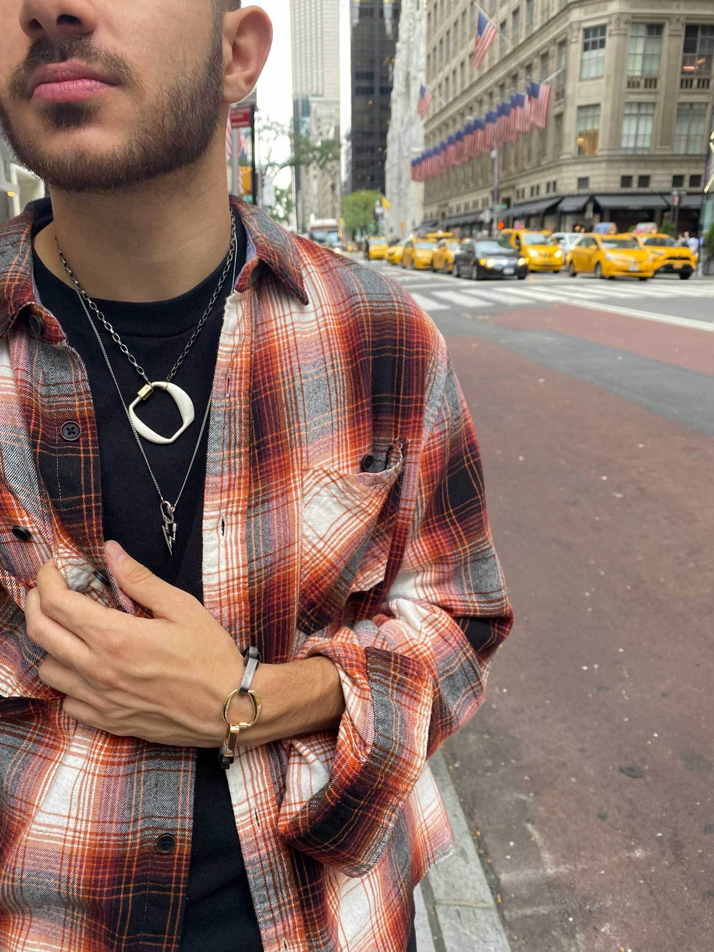 Close up of man's decolletage wearing necklace with O lock