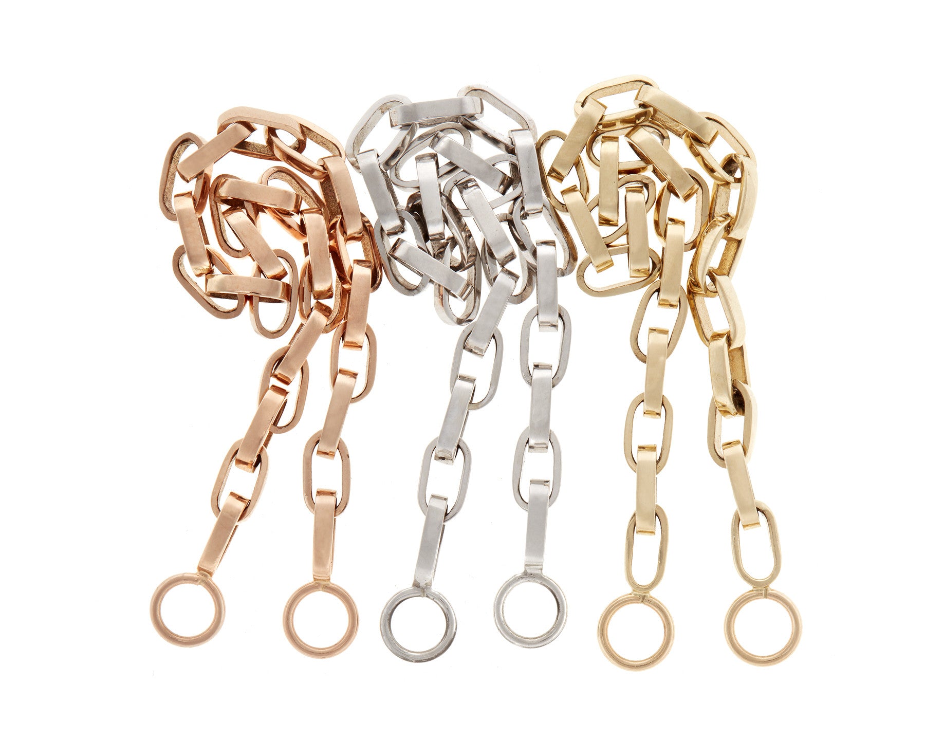 Rose gold biker chain, silver biker chain, and gold biker chain beside one another against white backdrop