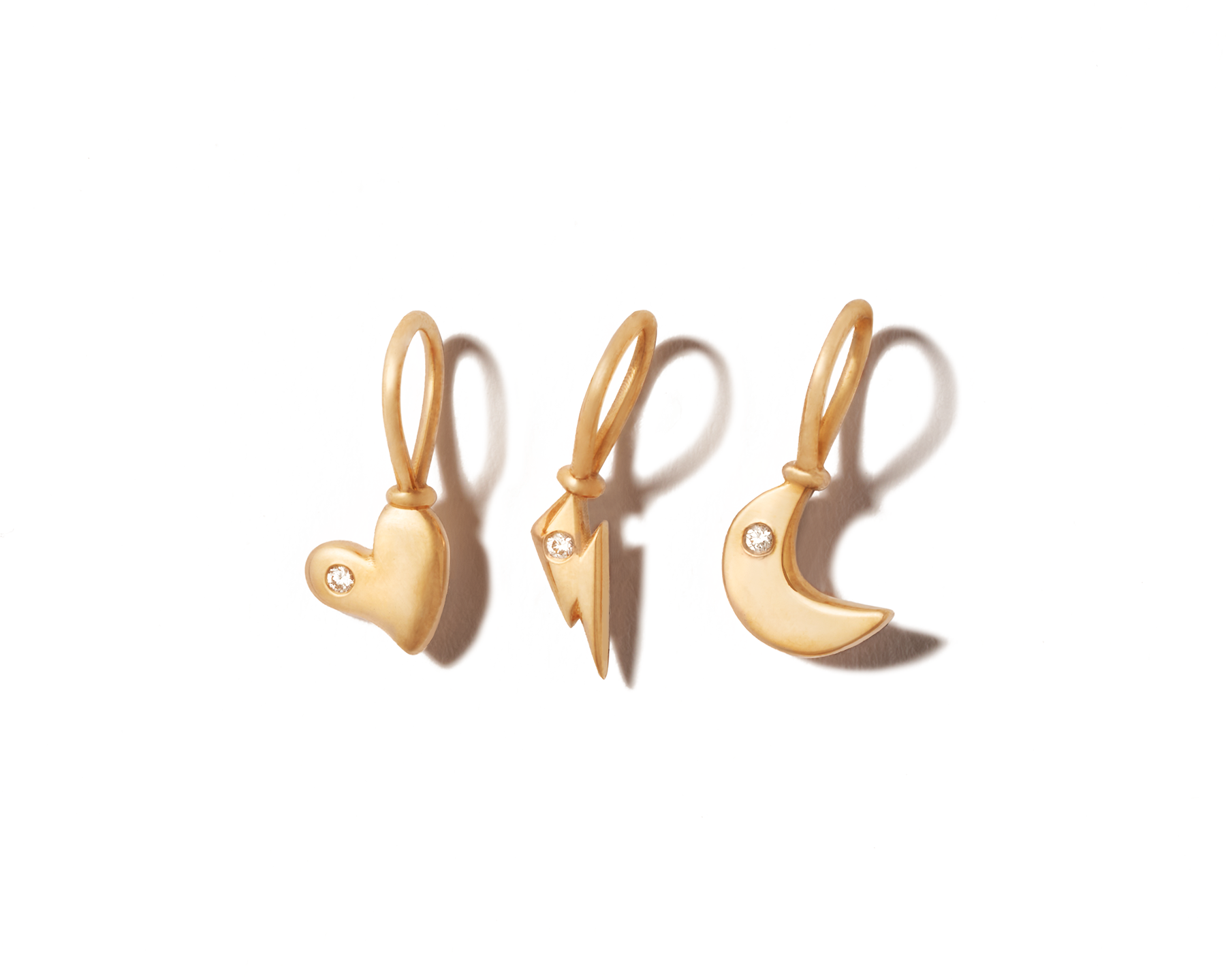 Three tiny gold charms lined up