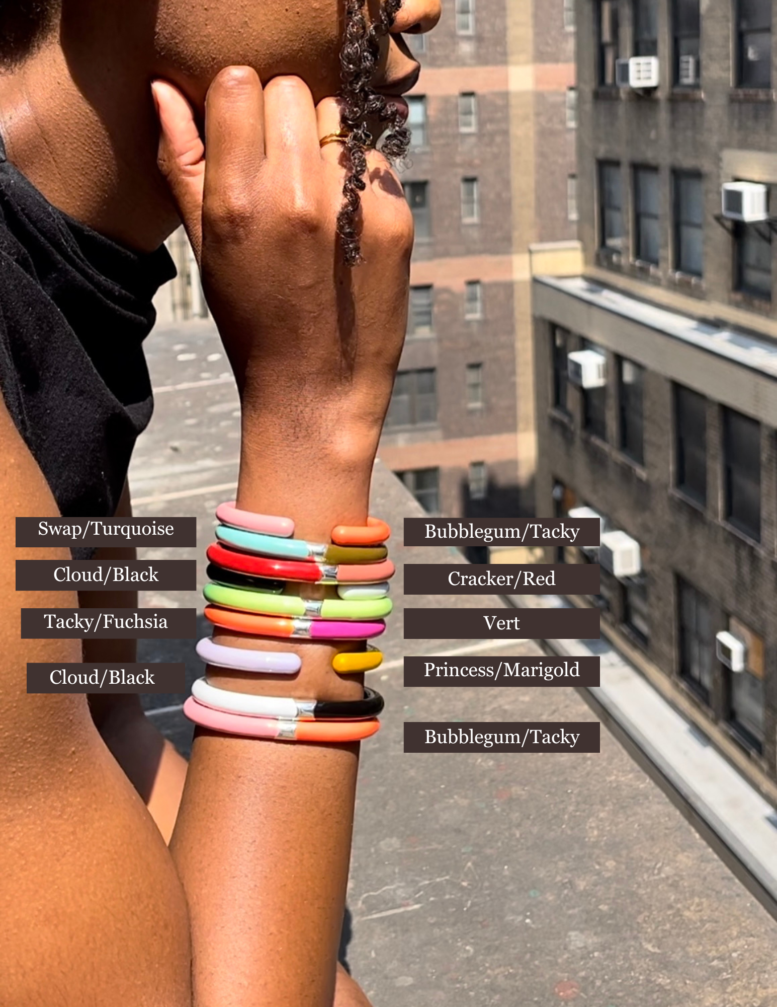 Close up of woman's wrist with many enamel cuff bracelets with colors labeled