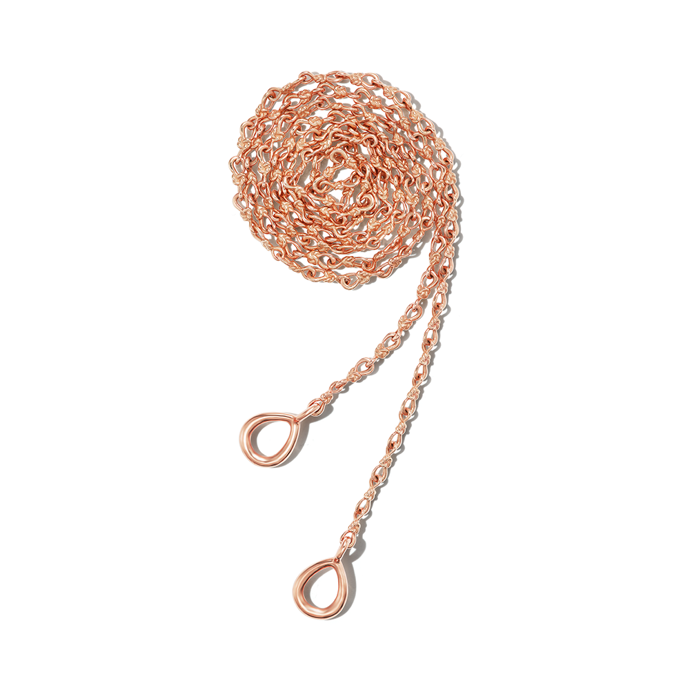 Wound up rose gold love knot necklace chain against white backdrop