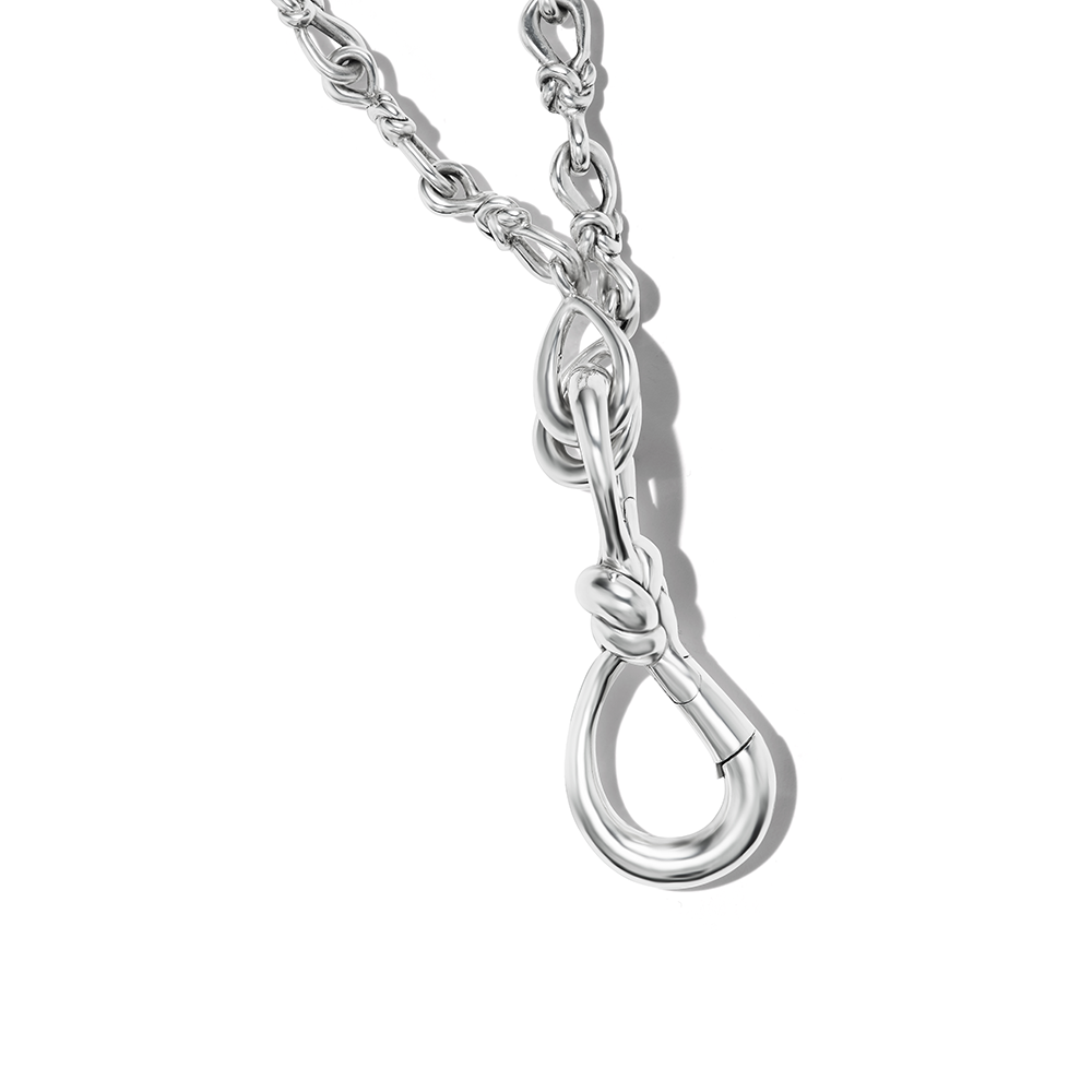 Close up of knot charm silver attached to silver necklace chain