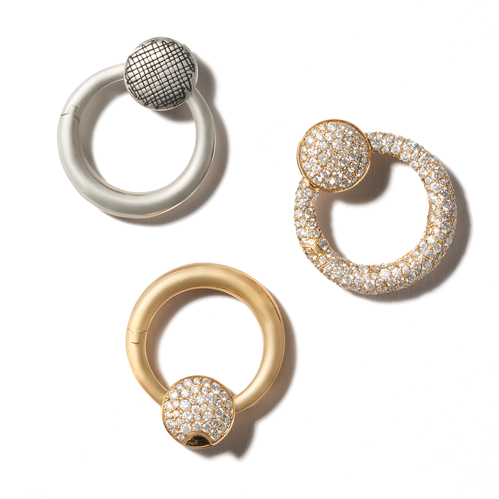 Three circular pendant charms including diamond studded pendant charm
