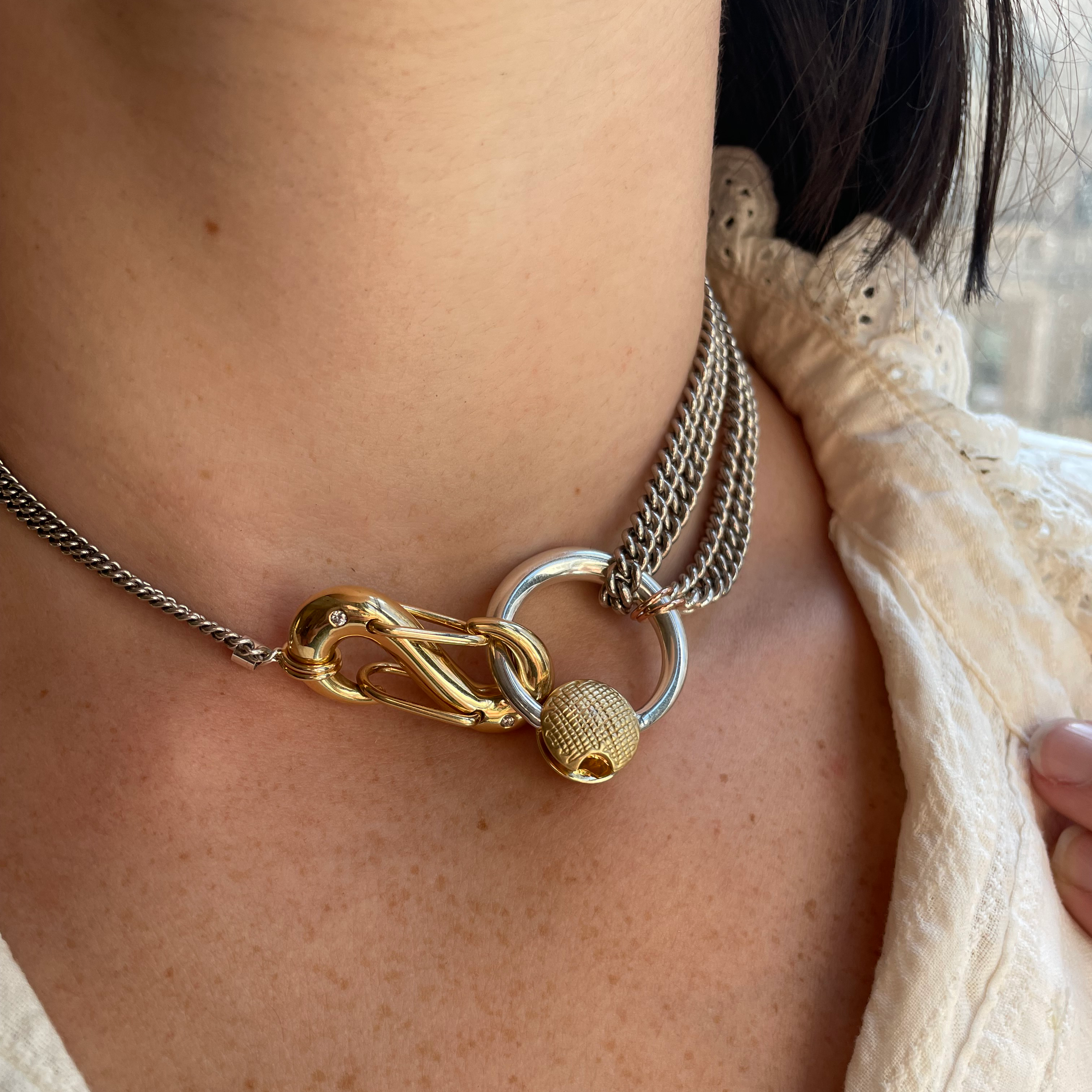 Close up of woman's decolletage wearing necklace with silver disc charm