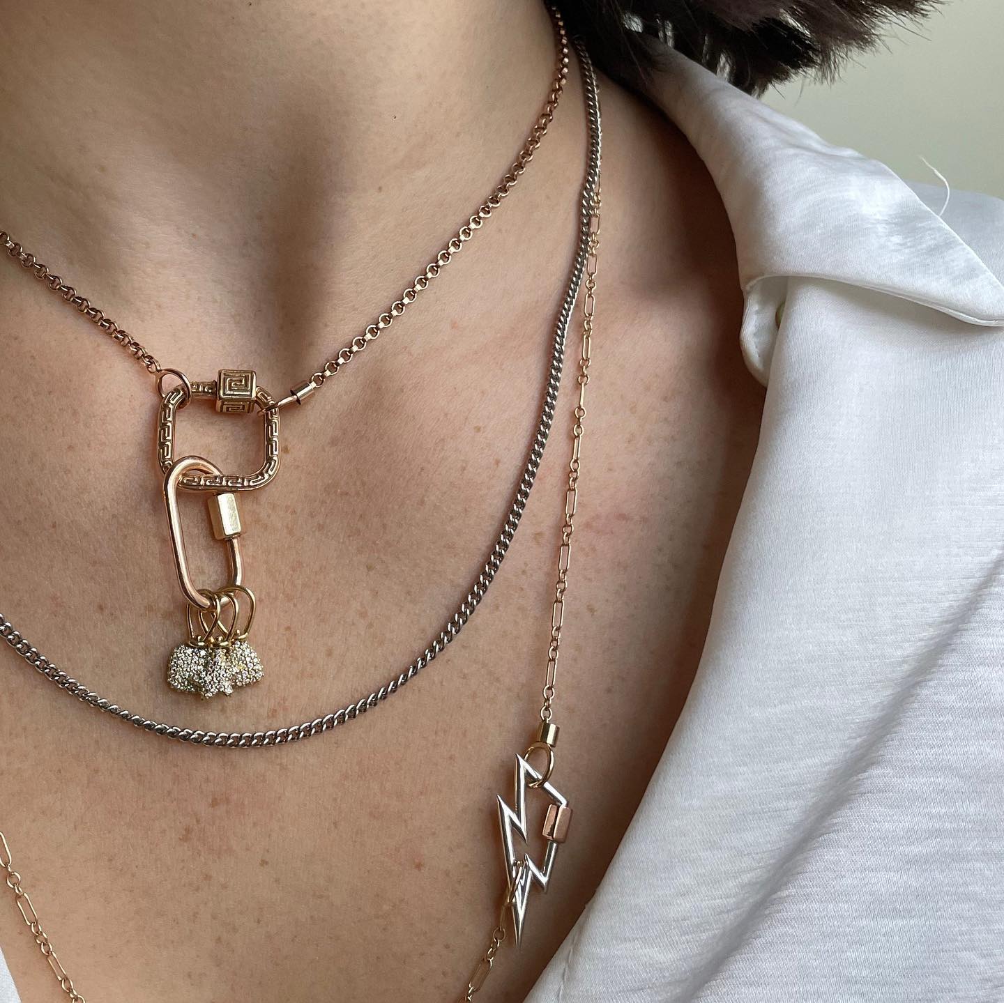 Close up of woman's neck wearing necklace with Greek key meander pendant