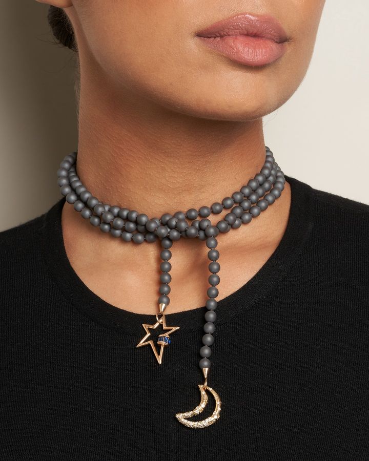 Woman wearing hematite bead necklace with moon and star charms