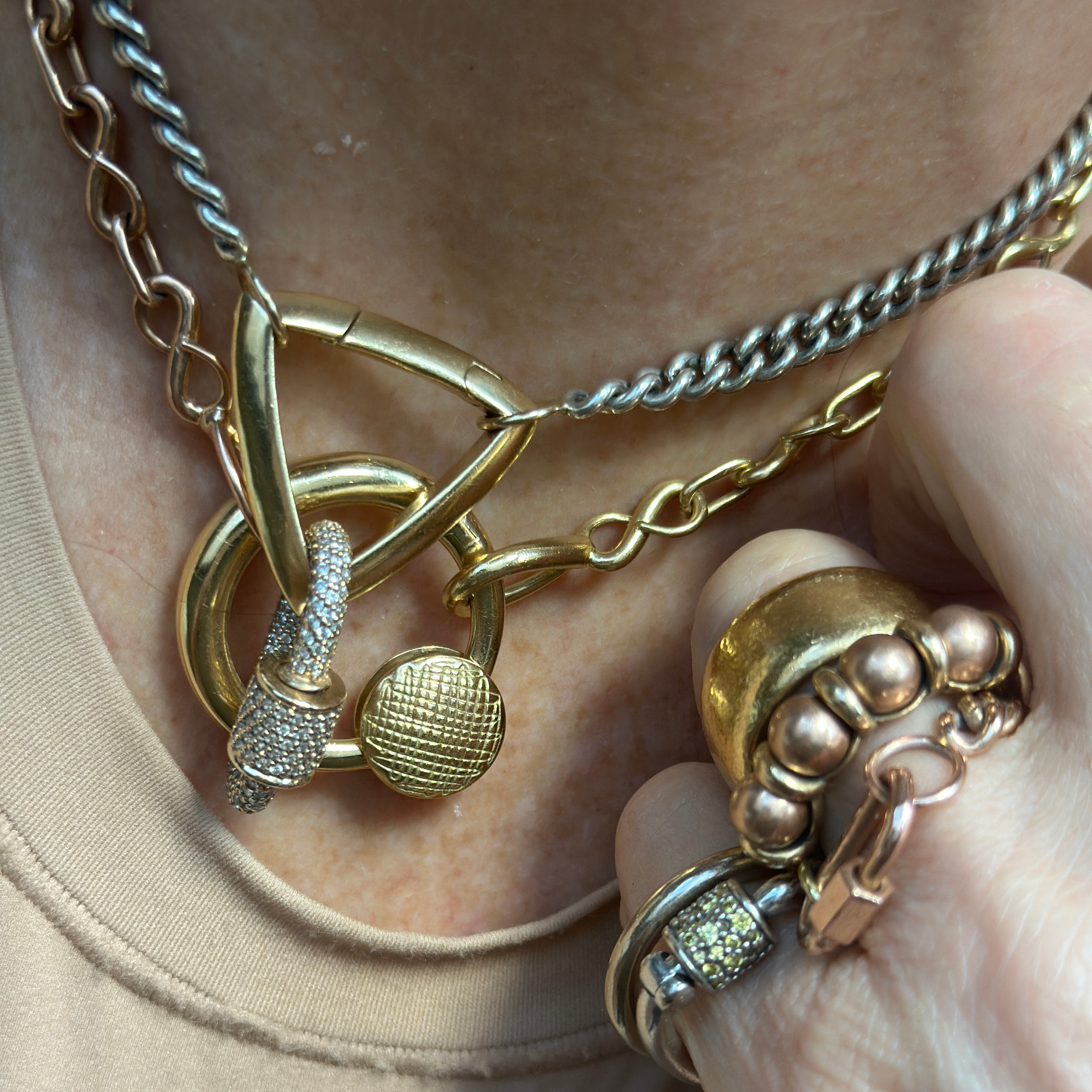 Close up of woman's decolletage wearing necklace with gold disc charm
