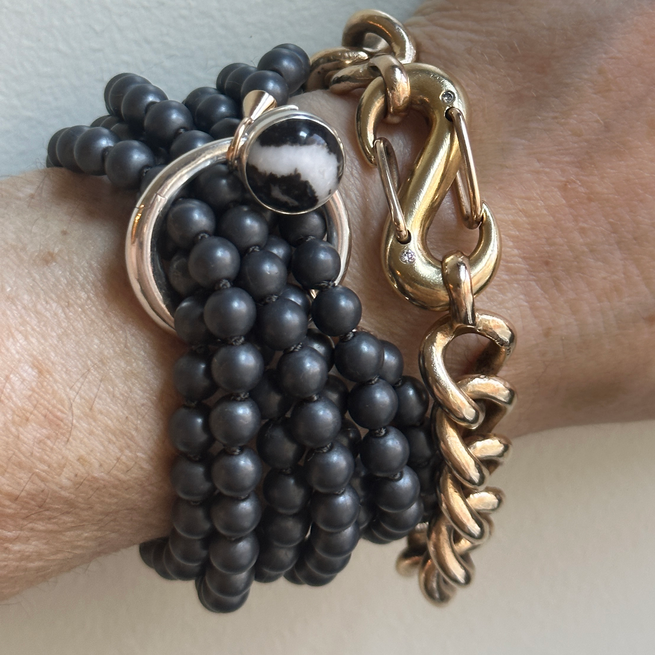 Close up of wrist wearing bracelet with stone disc charm