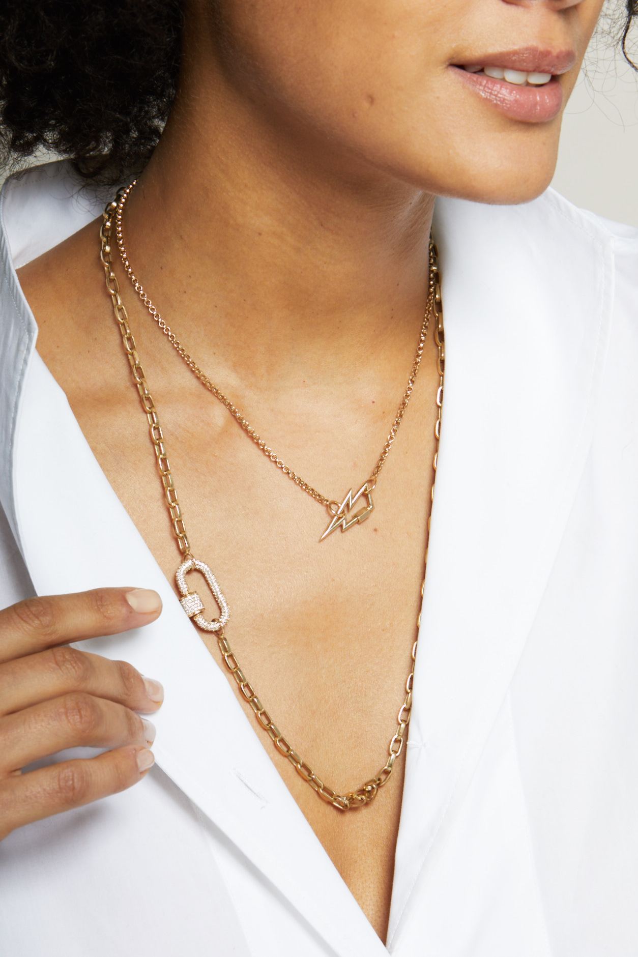 Close up of woman's decolletage wearing lightning bolt charm necklace