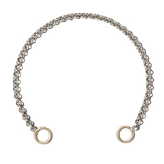 Close up shot of silver rolo chain with gold loops against white backdrop