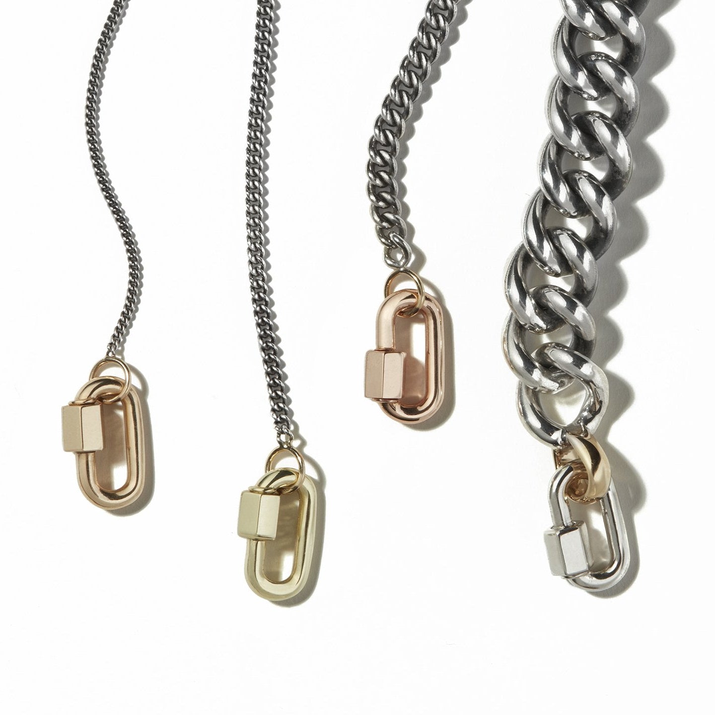 Four curb chains of different thicknesses with lock charms lined up next to each other  