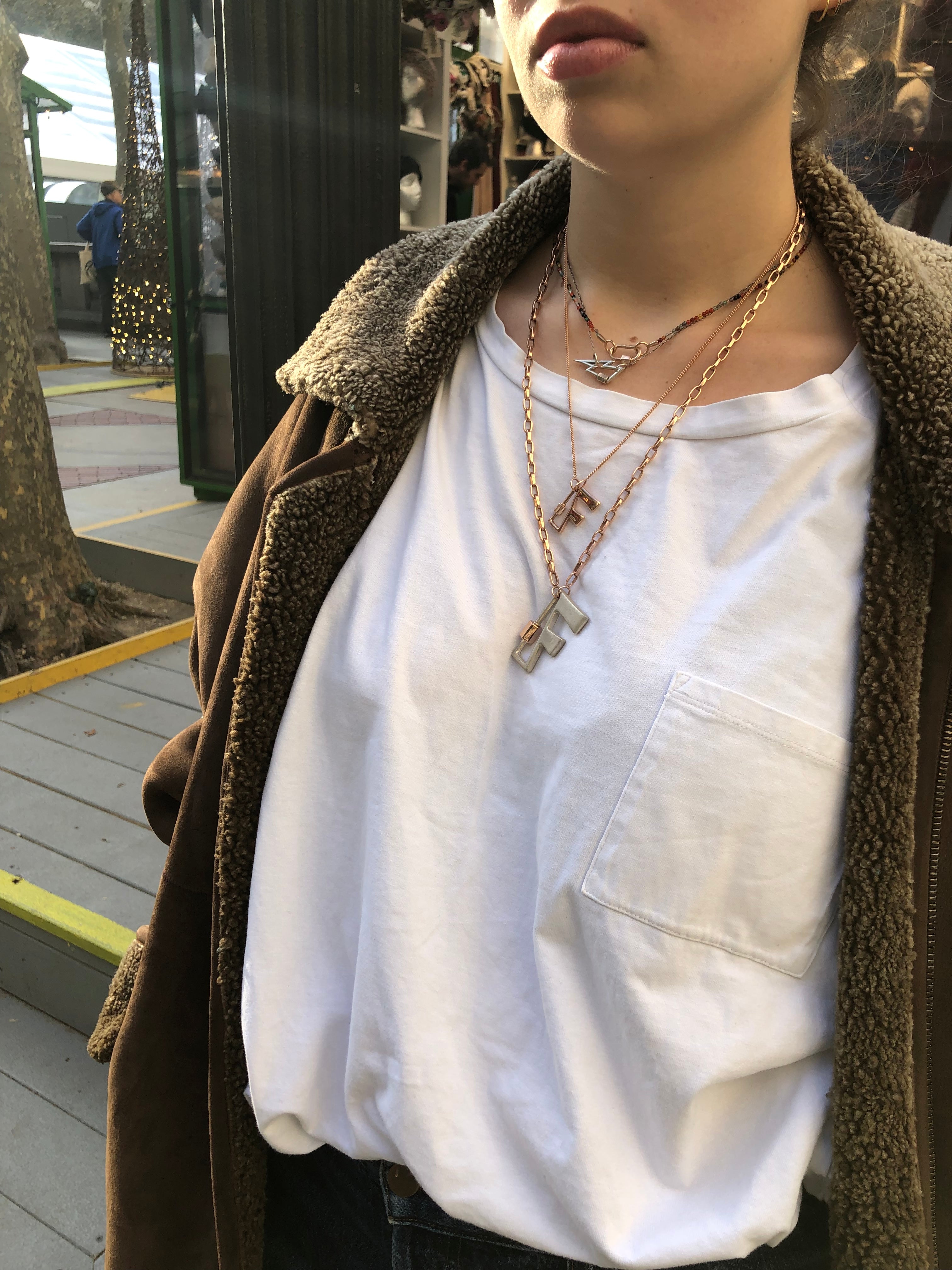 Woman wearing necklace with F lock