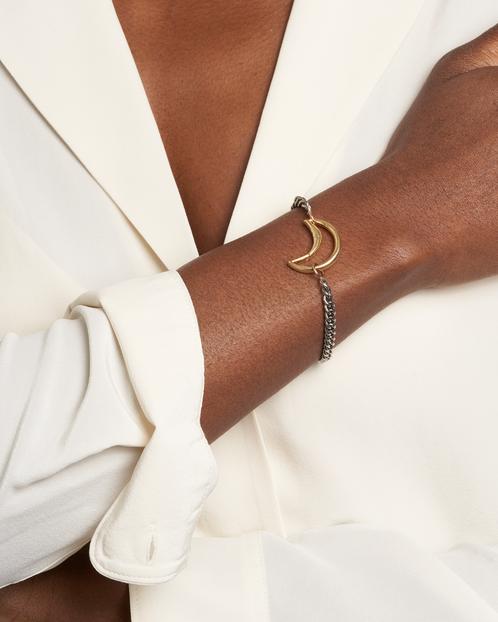 Close up of woman's wrist wearing bracelet with moon lock charm