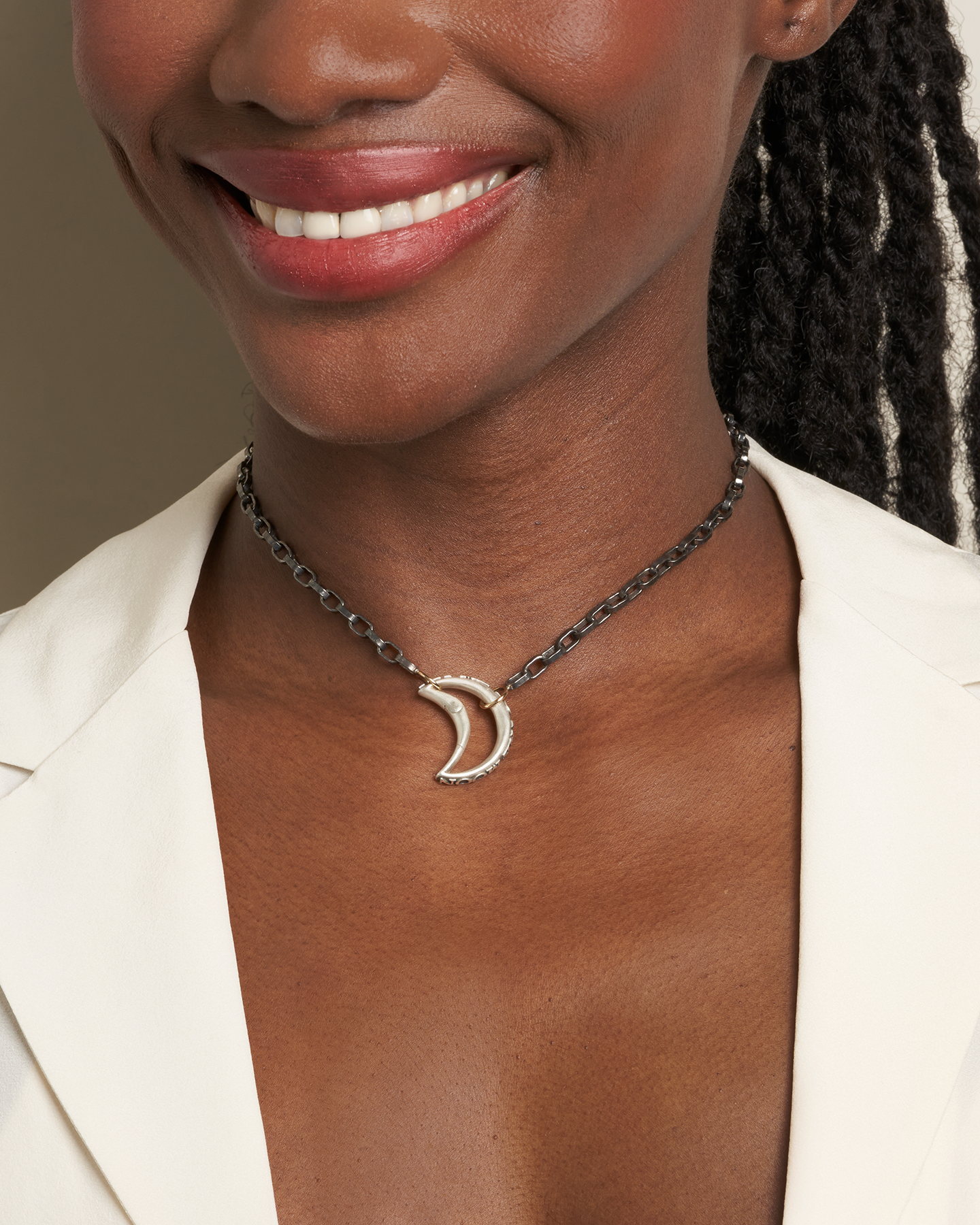 Close up of woman's forward-facing decolletage wearing fly me to the moon necklace