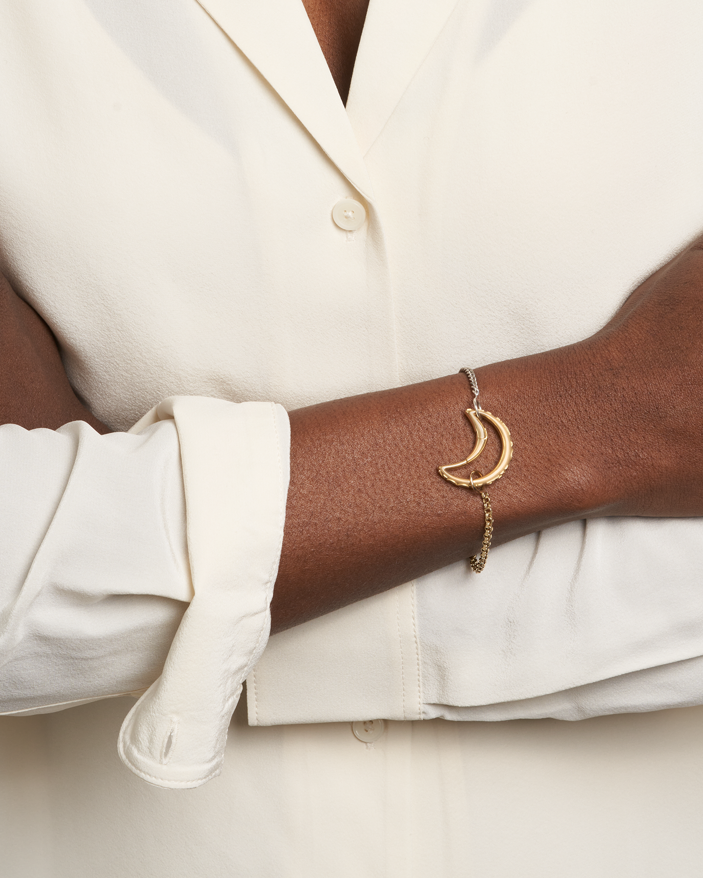 Close up of woman's wrist wearing silver and gold chain bracelet