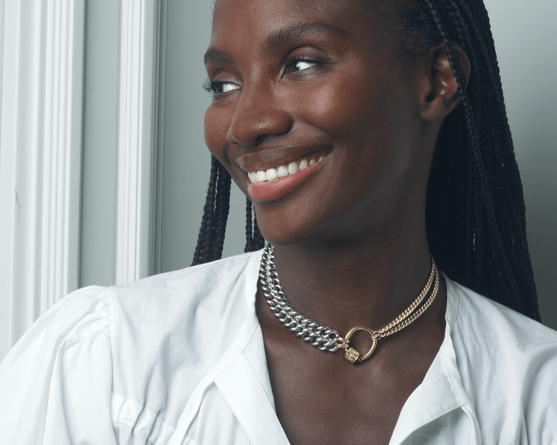 Portrait of woman smiling while wearing mixed metal thick curb chain necklace