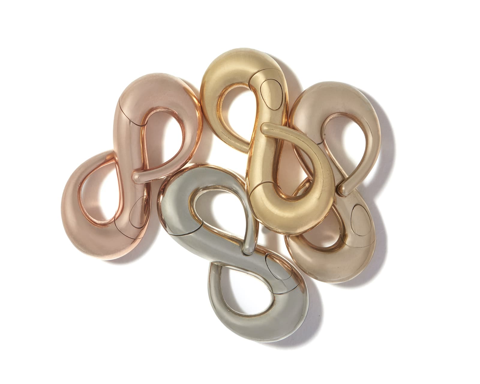 Pile of gold, silver, rose gold, and brown gold infinity charms