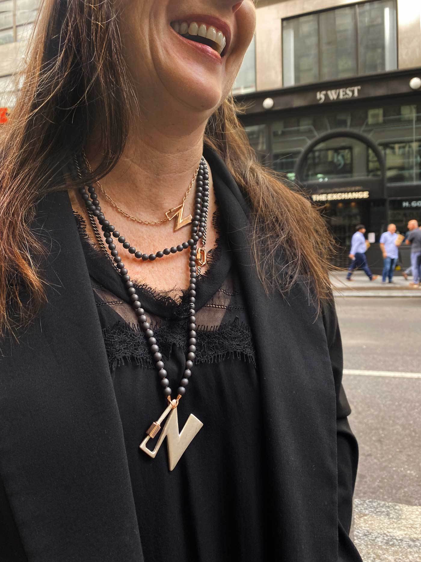 Close up of woman's decolletage wearing necklace with N lock