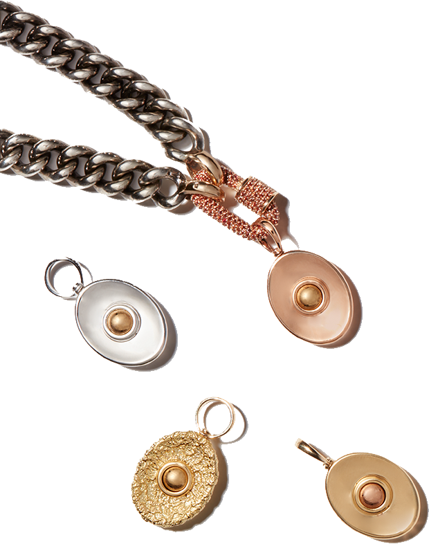 Customized pendant necklace with silver chain and rose gold charm surrounded by various other charms against white backdrop
