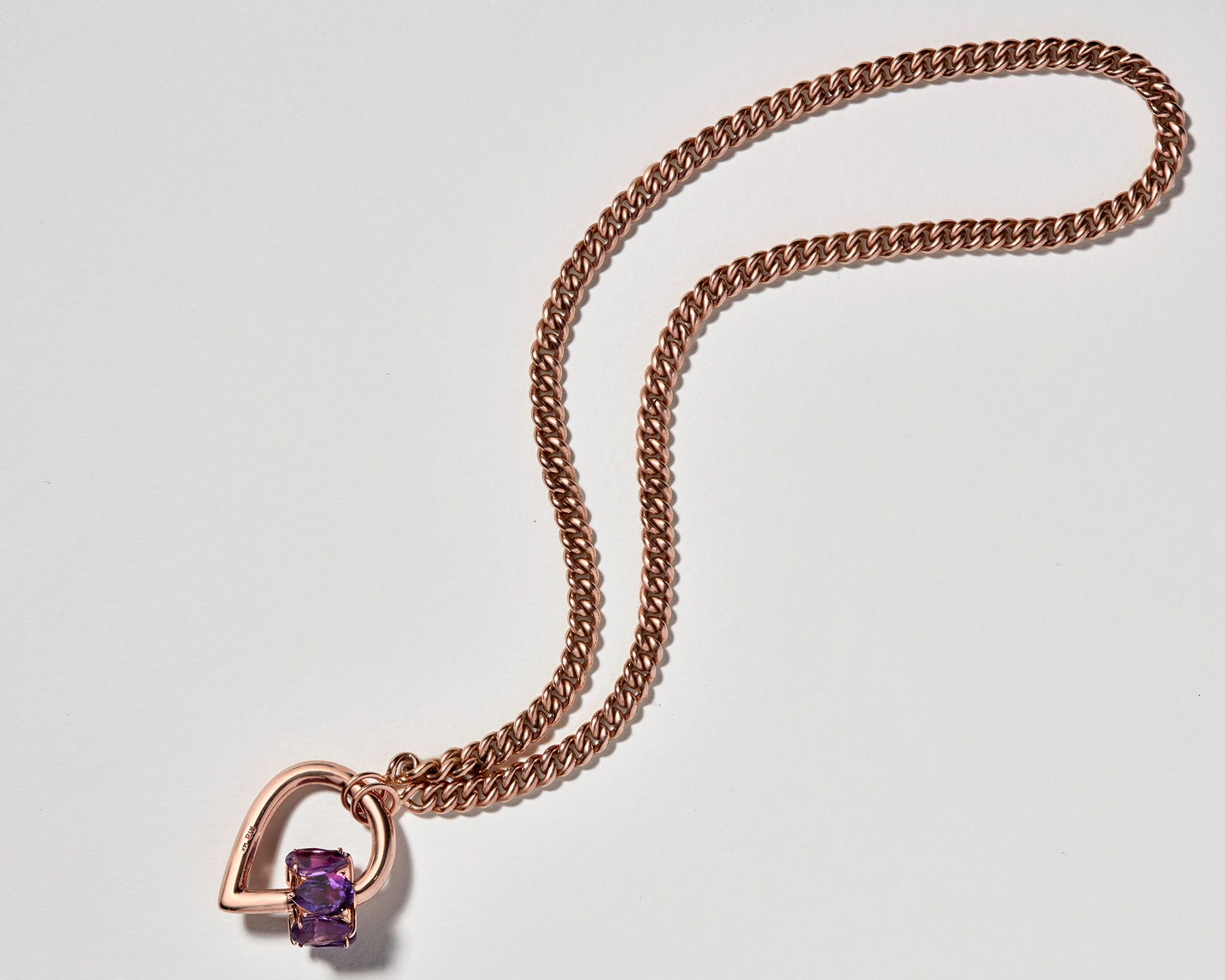Rose gold drop lock charm with purple gemstones attached to rose gold chain necklace